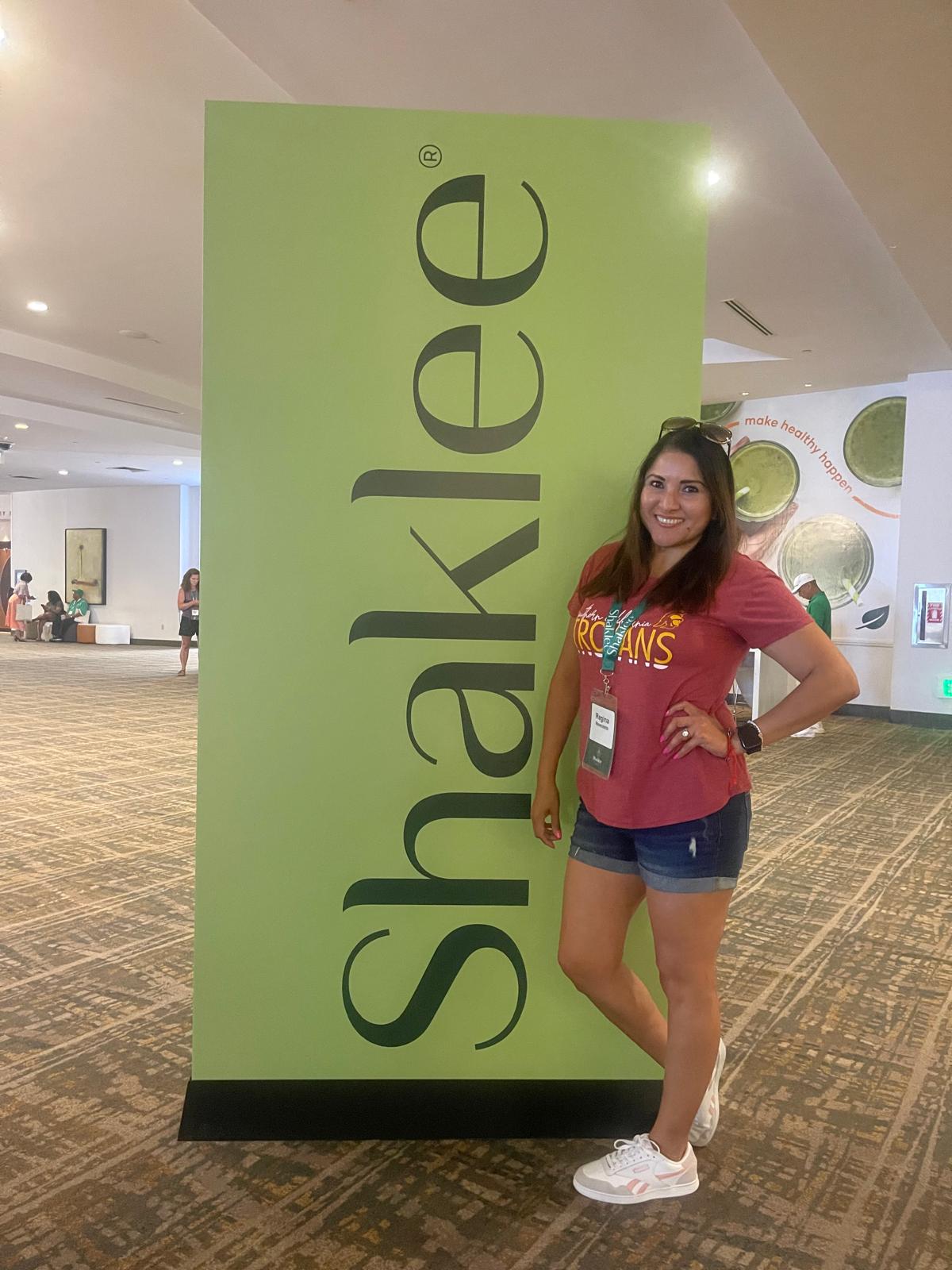 Regina posing with Shaklee sign